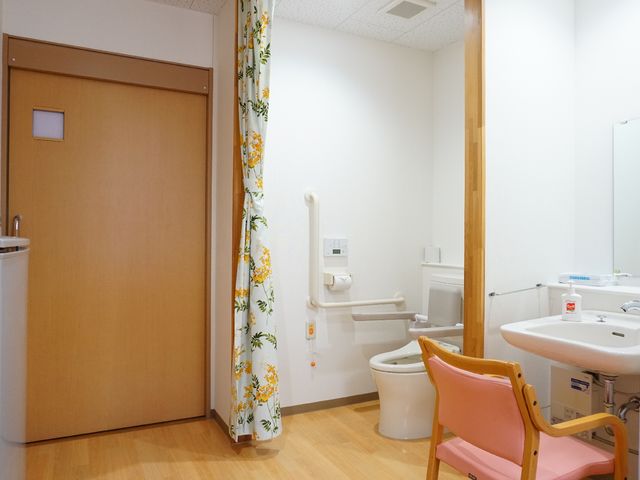 バリアフリーのトイレ設備 トイレ 手すりのついた清潔なトイレスペースです。個々のニーズに配慮した設計で、快適にご使用いただけます。