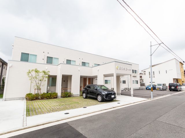 明るい外装の建物正面 外観 清潔感あふれる白を基調とした建物で、働く環境として充実した設備が整っています。周囲は静かで穏やかな印象を受けます。