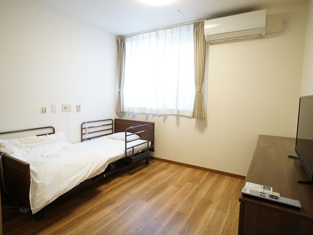 清潔な個室の居室 居室 ゆったりとしたベッドが設置された居室です。部屋は明るく清潔感があり、プライバシーが尊重された空間となっております。