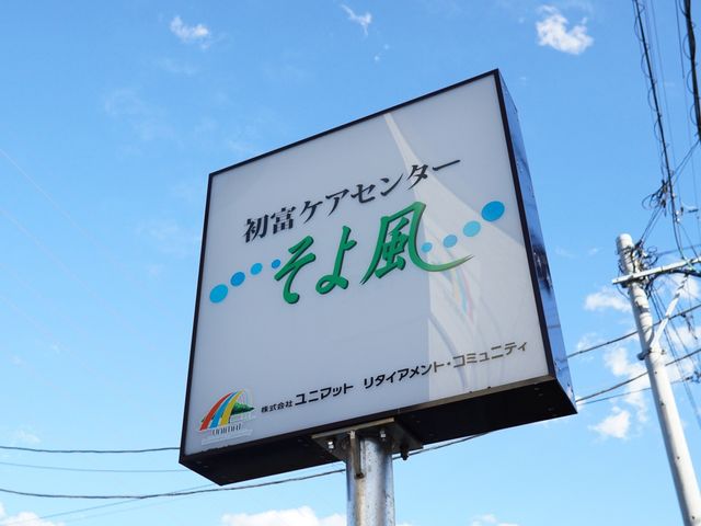 看板のクローズアップ ロゴ 青空に映える清潔感のある看板が設置されており、心地よい職場環境を予感させます。