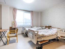 明るい個室のベッド並ぶ居室  