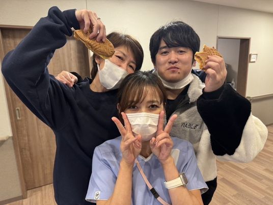 笑顔のスタッフ3人が並ぶ食堂  