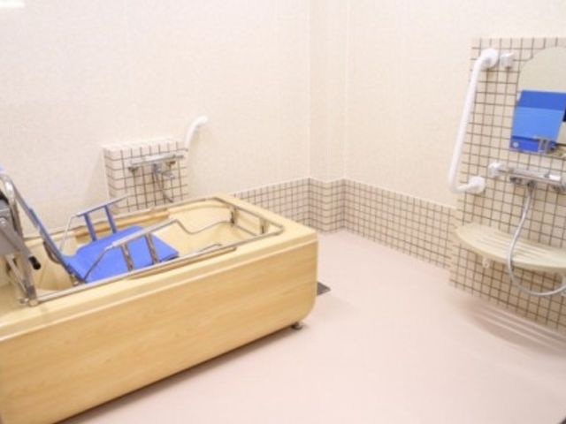明るい入浴設備 浴室 明るく清潔感のある入浴スペースです。手すりや椅子が備えられており、安全に配慮された設計となっています。