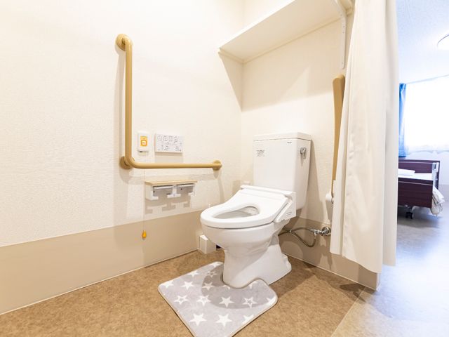 バリアフリートイレ設計 トイレ 安全に配慮されたトイレは、手すり付きで使いやすさを考慮しています。快適さと機能性を兼ね備えた環境で、ご利用者の日々をサポートいたします。