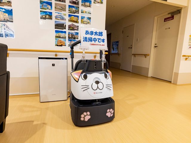 猫の形をしたロボット廊下 共有スペース ユニークな猫の形をしたロボットが迎える明るい空間です。技術を取り入れた快適な環境での勤務をご希望の方に適しています。