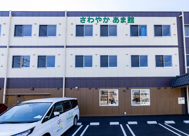 清潔感のある施設外観 外観 広々とした駐車スペース、気持ちの良い青空の下に佇む快適な施設です。利用者様の日々の生活をサポートします。