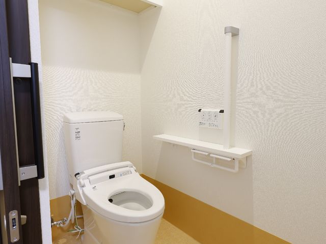 バリアフリーのトイレ トイレ 手すり付きで安全に配慮した清潔なトイレです。利用者の自立支援を考えた設計になっており、快適にお使いいただけます。