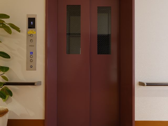 木目調の洗面台のアップ エレベーター 機能的なデザインの洗面台が整っており、清潔感あふれる空間で働ける環境を提供しています。