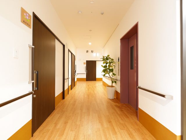 暖かみのある廊下の様子 廊下 明るく清潔感のある廊下が、日々の業務を快適に支えます。手すりが設置されており、安心して歩行できる環境です。