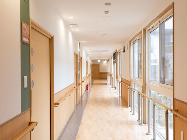 温かみのある廊下 廊下 手すりが備え付けられた明るく広々とした廊下です。こちらの空間では、ご利用者さまの安全な移動を支援しています。