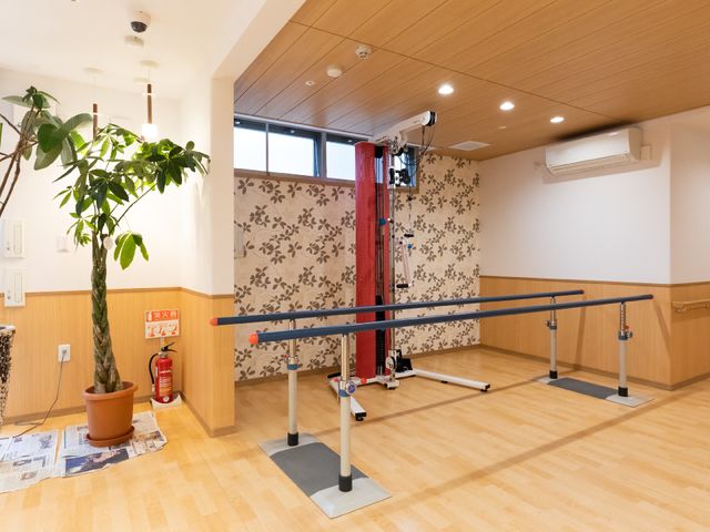 機能訓練室の設備 機能訓練室 充実した訓練設備が整う機能訓練室です。そこでは明るい光が差し込み、広々とした空間で利用者様のリハビリを支援しています。