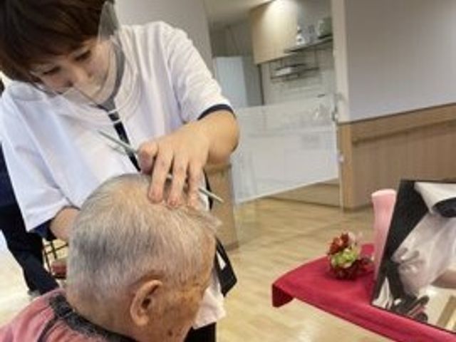 理美容の時間 訪問理美容 職員が丁寧な手つきで理美容のサービスを提供しており、心地よい手入れを受けている様子です。ゆったりとした居心地の良い空間で業務が行えます。