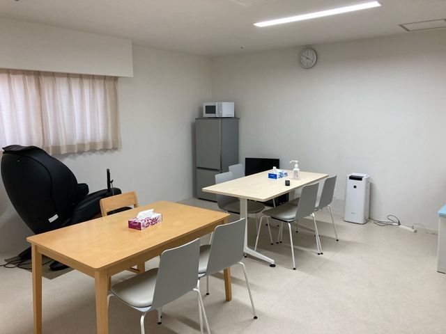 休憩室のテーブル席 休憩室   テーブル席が2組あり、飲み物や手指消毒用の備品も置かれています。窓からのやわらかな光で、落ち着いて休憩しやすい空間です。