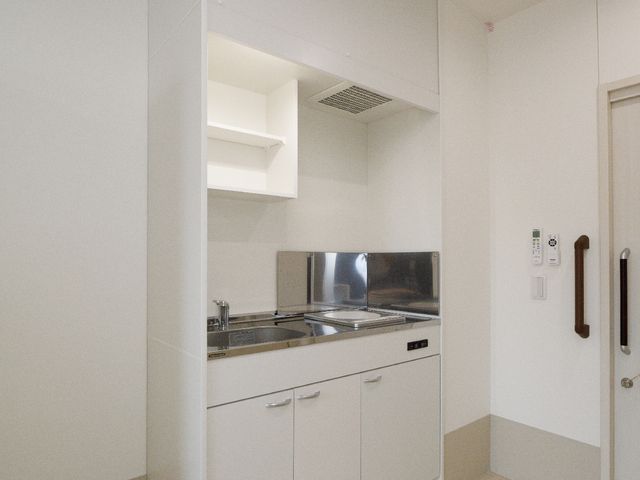 清潔なキッチンのコーナー キッチン シンプルで使いやすいキッチンが整っており、居室での自炊も快適です。働く環境としても居心地の良い空間です。