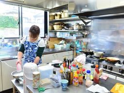 調理中の女性とキッチン