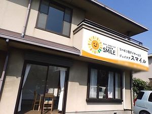 笑顔の看板付き建物外観