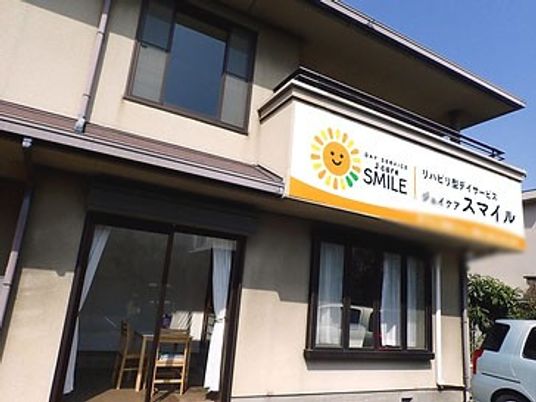 笑顔の看板付き建物外観