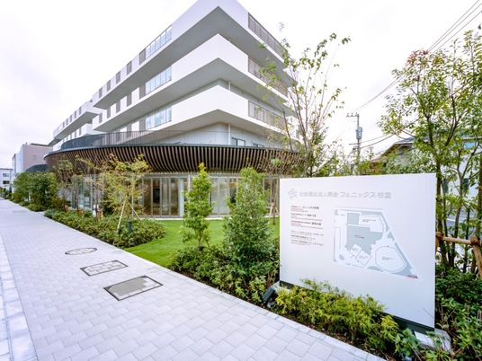 緑に囲まれた建物の外観  