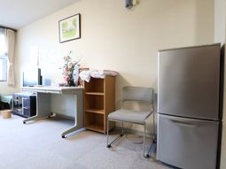 事務用デスクと冷蔵庫の居室