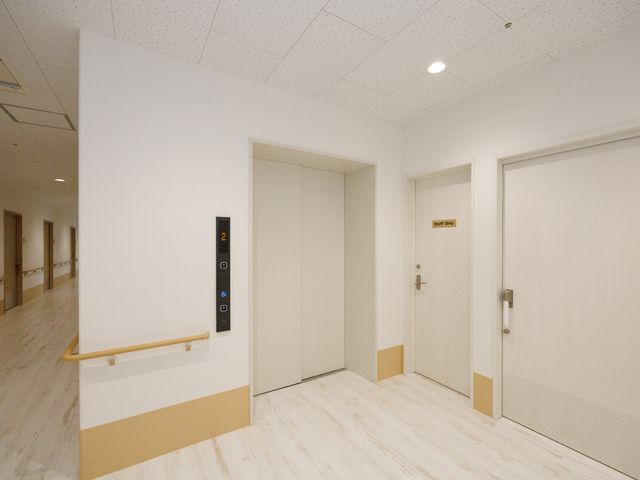 清潔な廊下とエレベーター エレベーター すっきりとした廊下には、スタッフ専用の扉とエレベーターが備えられ、安全で円滑な業務が行える設計です。