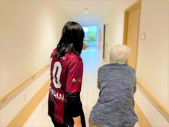 長い廊下 廊下 介護士が利用者の方と一緒に歩きやすい廊下を進んでいます。明るく開放的な雰囲気です。