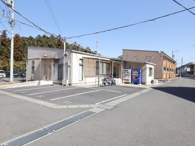 明るい日差しの外観 外観 ゆとりのある駐車スペースを備えた建物です。青空の下、自然な光が差し込む落ち着いた雰囲気の場所でのお仕事をご検討ください。