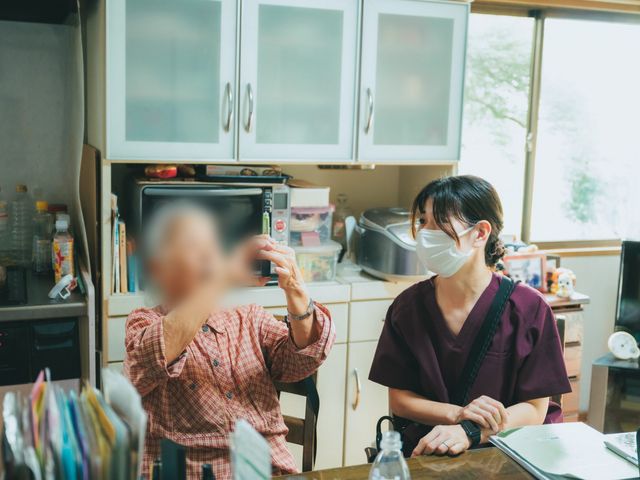 会話する二人の様子 キッチン 広々としたキッチンで、スタッフが利用者と和やかに会話しています。自然光が差し込んで明るい空間です。