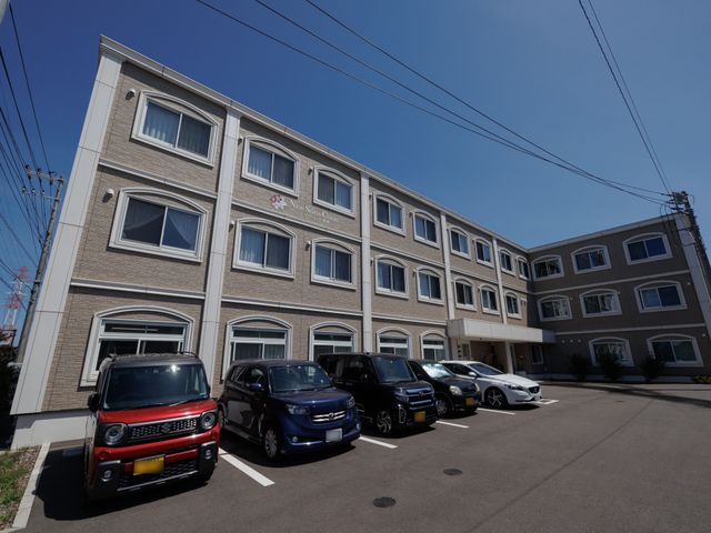 施設外観の明るい日差し 外観 ゆとりある駐車スペースを有する快適な施設です。明るく開放的な環境で皆様のお越しをお待ちしています。