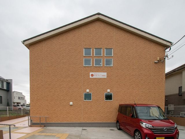 レンガ色の建物外観 外観 明るいレンガ色の建物が、訪れる方々を暖かく迎えます。駐車スペースも整えられており、来訪が便利です。