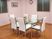 サムネイル 施設の写真 ピンクの壁紙が特徴的な明るいダイニングである。天板がガラス製の６人掛けダイニングテーブルが置かれている。