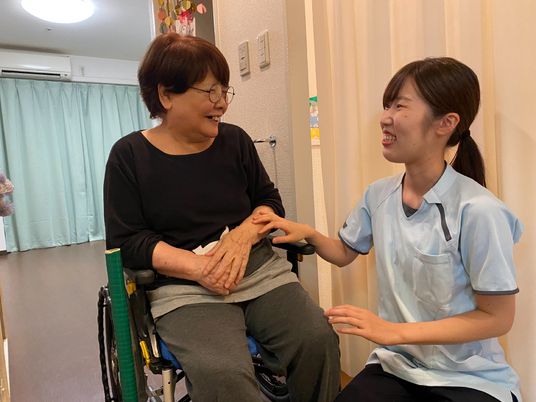 笑顔で会話するケアワーカーと利用者