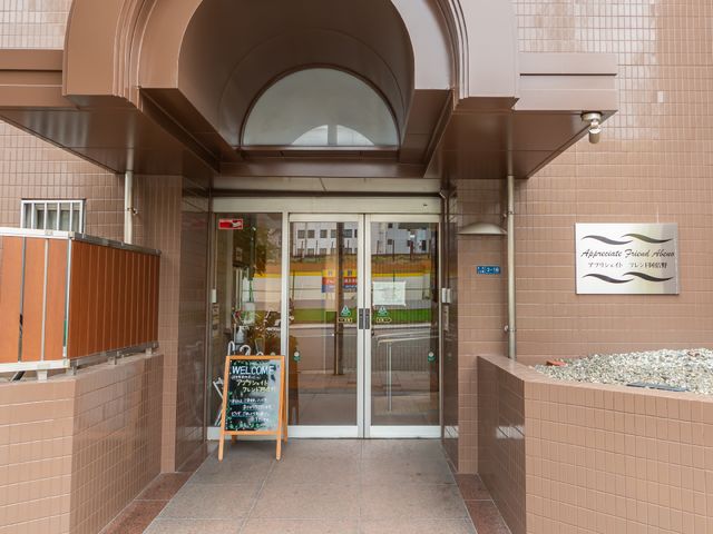 温かみのあるエントランス 玄関 歓迎感のあるエントランスには手書きの案内板が置かれ、訪れる方々への配慮が感じられます。