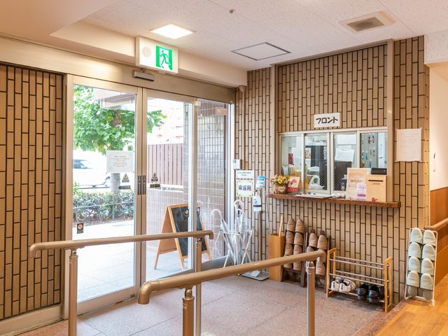 明るい入り口エリア 玄関 ガラス扉越しに見える自然光が満ちたエントランスです。椅子と情報コーナーが設けられ、待合にもご利用いただけます。