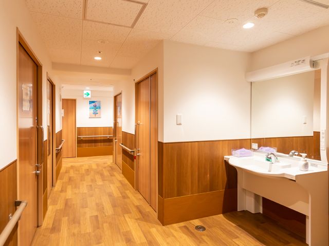 清潔感のある廊下と洗面台 廊下 手すり付きで安全に配慮された廊下です。洗面台も備えており、快適な生活環境が整っています。