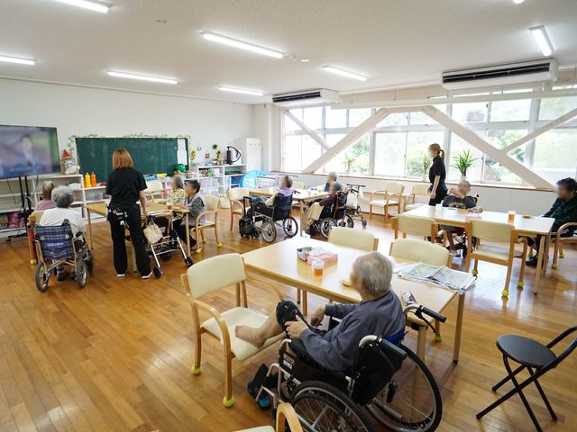 共有スペースの日常シーン 共有スペースA ゆったりとした多目的室で、利用者の方々が様々な活動に親しんでいます。気光に満ちた空間での豊かな日々を、ぜひ一緒に支えていただけませんか。