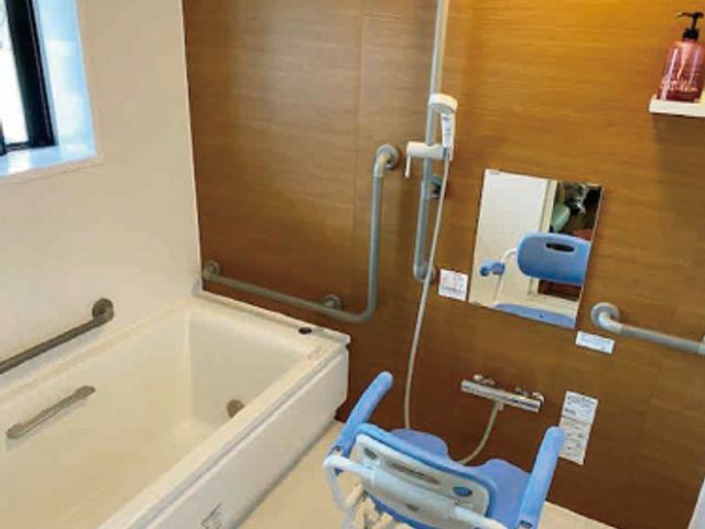 手すり付きお風呂 浴室 手すりが設置された安全な入浴スペースです。使いやすいシャワーチェアもあり、安心して介助できます。