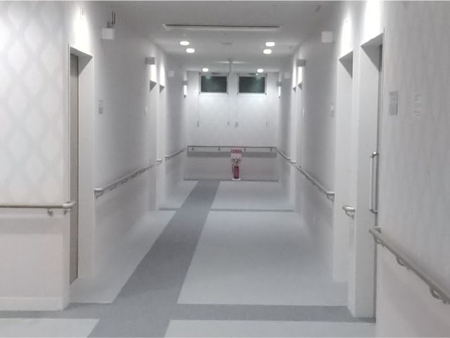 明るい廊下の様子 廊下 手すりが設置された清潔感のある廊下です。静かで落ち着いた雰囲気が感じられます。