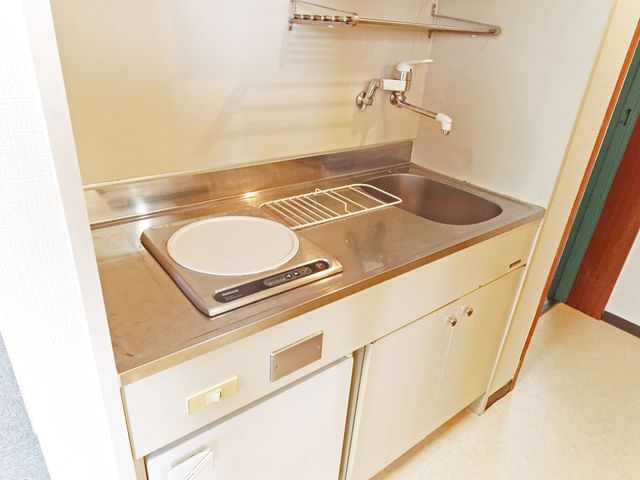清潔な共用キッチン キッチン   ステンレスの作業台にIHコンロと流しがまとまり、見やすく使いやすい印象です。調理や準備がしやすそうな、すっきりしたキッチンです。