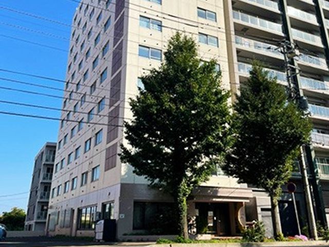 外観の建物と街路樹 外観   明るい外壁の建物前に街路樹があり、落ち着いた雰囲気です。出入口まわりも見通しがよく、初めての方にも分かりやすそうです。
