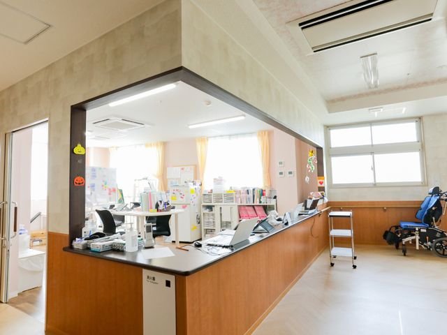 明るいナースステーション ナースステーション 広々としたナースステーションでは、スタッフが利用者様のサポートを行っています。整理されたデスク周りも印象的です。