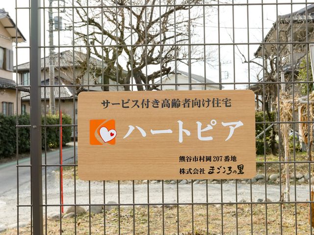 案内板に掲示された看板 看板 安らぎと健やかさを象徴するハートマークが目を引く案内板が、来訪者を優しく迎えます。明確な住所表示が迷わずアクセスするためのポイントです。