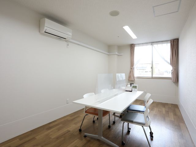 明るい会議室風の部屋 相談室 シンプルで清潔感あふれる空間です。窓から自然光が差し込み、落ち着いた時間を過ごせる環境が整っています。