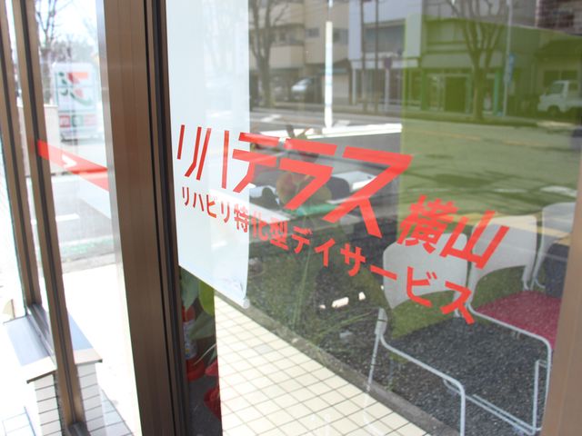 サービスの看板 看板 ガラスに描かれた施設のサービス名が明るく見えます。シンプルで視認性の高いデザインです。