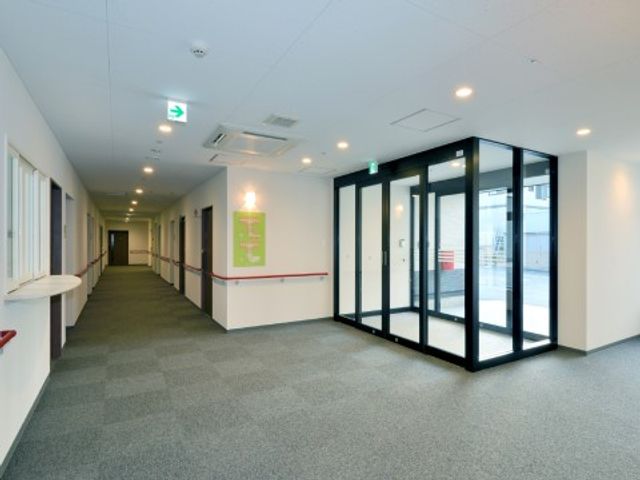 明るい廊下と休憩スペース エントランス 広々とした廊下にはベンチが設置され、明るく開放的な休憩スペースがあります。ゆったりとした環境で、お仕事に取り組める空間です。