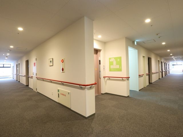 広々とした明るい廊下 通路 手すり付きの清潔感のあふれる廊下が、日々の業務をサポートします。周囲は明るく、清潔で落ち着いた雰囲気が漂っています。