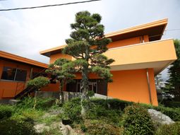 オレンジ色の建物と緑豊かな庭