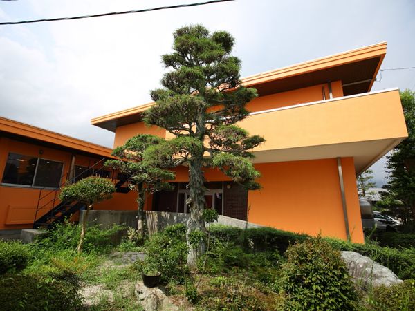 オレンジ色の建物と緑豊かな庭