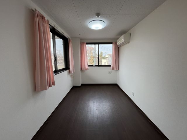 明るい空間の居室 居室 大きな窓から自然光が差し込む明るいお部屋です。エアコンが設置され、快適な環境が整っています。