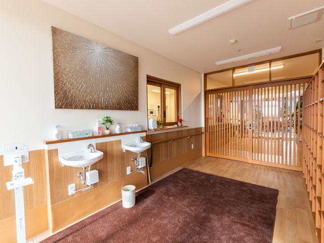 和風の洗面所と廊下 洗面台 清潔感のある洗面台が並び、落ち着いた色合いの廊下が見えます。仕事を通じて快適な環境づくりに貢献できます。