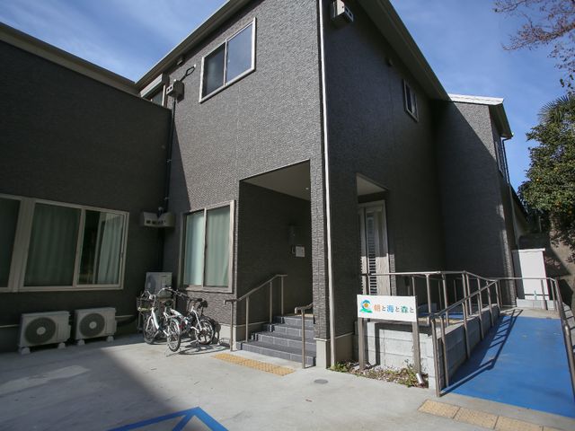 明るい建物のエントランス 外観 バリアフリー設計が施されているエントランスは、快適な出勤をサポートします。日差しが心地よく差し込む、清潔感のある入口がお出迎えします。
